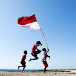 Anak-anak membawa bendera merah putih di desa pesisir pulau Ndao, Rote, Nusa Tenggara Timur